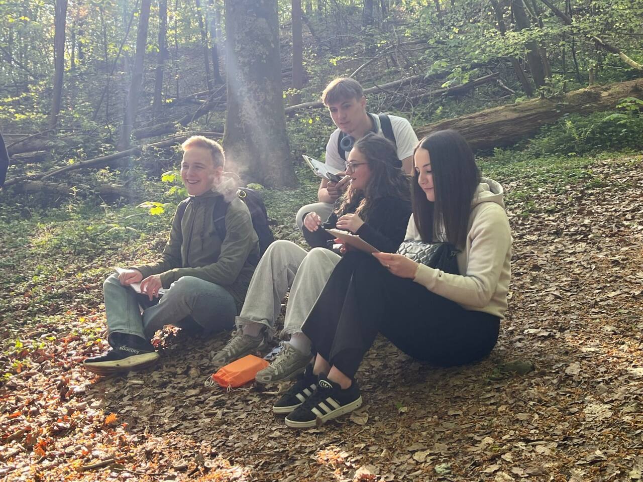 Élèves assis en forêt, moment d'échange
