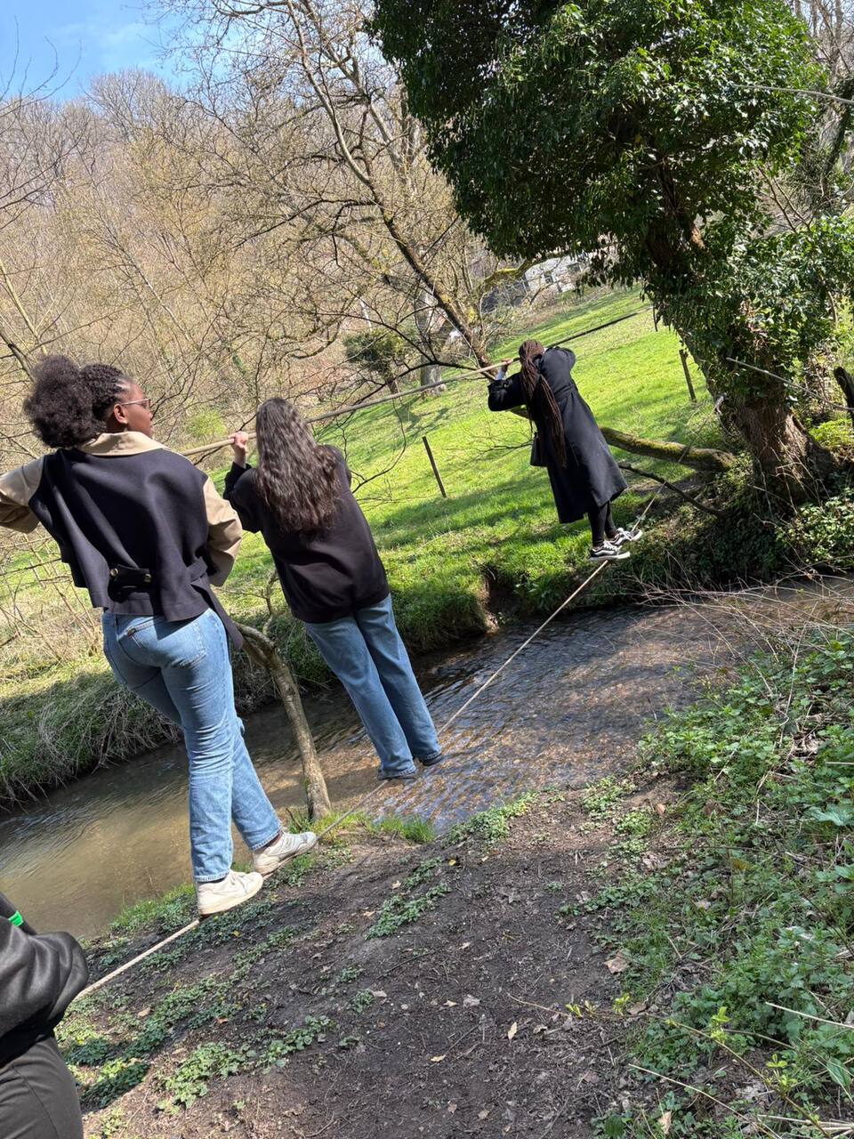 Élèves franchissant un ruisseau en équipe