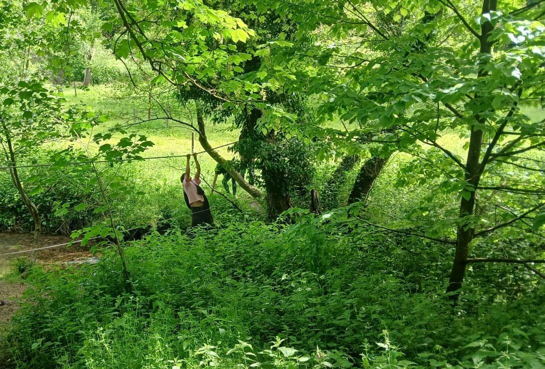 Adulte en exercice sensoriel suspendu à une corde en forêt