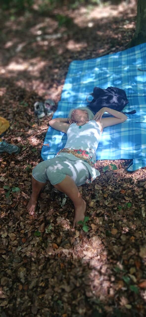 Adulte allongé et détendu sur une couverture en forêt